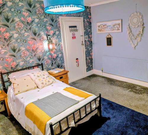 a bedroom with a bed and floral wallpaper at Spacious Single Bed Room near Newhaven Town Centre in Tarring Neville
