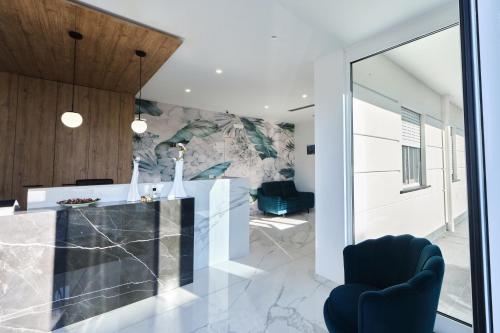 a kitchen with a marble counter and blue chairs at Le perle del golfo Scafati in Scafati