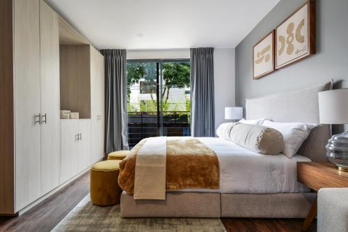 a bedroom with a large bed and a window at The Sterling Condesa in Mexico City