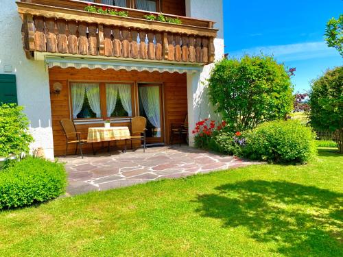 a house with a balcony with a table and chairs at Ferienhaus Cosima in Schwangau