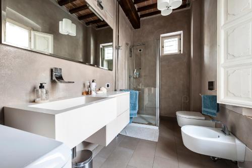 ein Badezimmer mit Waschbecken, Toilette und Spiegel in der Unterkunft Spacious 2BR Apartment for Families Central & Quiet Pisa in Pisa