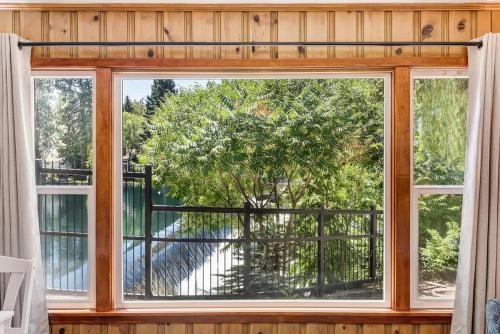 a window with a view of a tree at Ground Floor Riverside Cottage with Patio in Bend