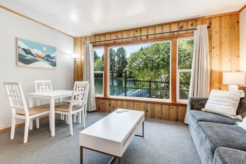 a living room with a couch and a table at Ground Floor Riverside Cottage with Patio in Bend