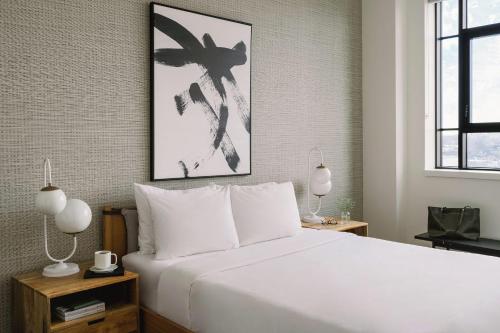 a bedroom with a large white bed with two lamps at The Cove Hotel - Plateau Mont-Royal in Montreal