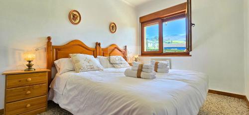 a bedroom with a large white bed with a window at Villa Trinamar - Casa rural en Valdes cerca de Luarca in Carcedo