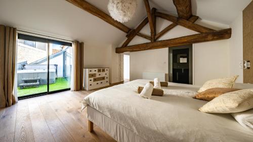 a bedroom with a large bed and a large window at Maison ALMA Piscine -Baby Foot - Cheminée- Jacuzzi in Vantoux