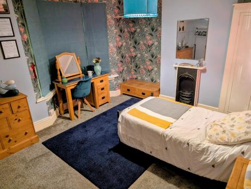 a bedroom with a bed and a dresser and a fireplace at Spacious Single Bed Room near Newhaven Town Centre in Tarring Neville