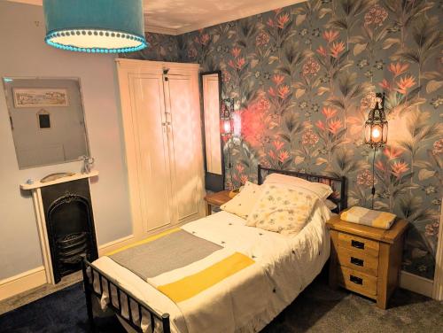 a bedroom with a bed with a floral wallpaper at Spacious Single Bed Room near Newhaven Town Centre in Tarring Neville