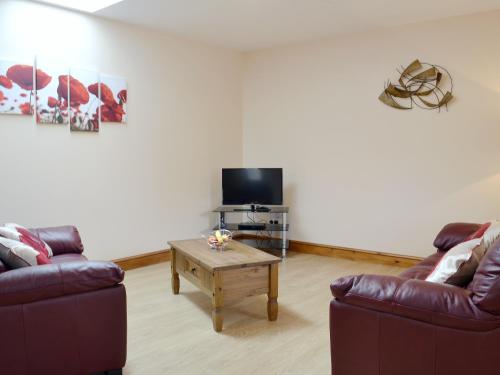 a living room with two couches and a tv at The Parlour - Op4 in Carmarthen