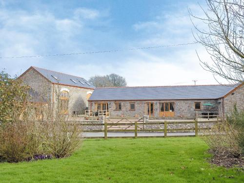 a brick barn with a fence in front of it at The Parlour - Op4 in Carmarthen