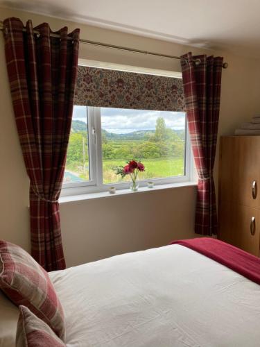 a bedroom with a bed and a window with a view at Rosehill annexe in Knighton