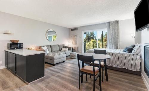 a kitchen and living room with a couch and a table at Updated Condo with Deschutes River View in Bend