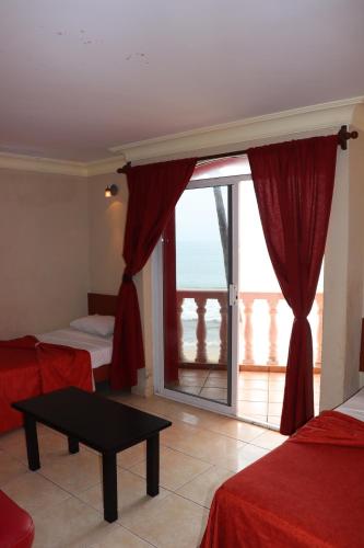 a room with two beds and a large window at Hacienda Blue Bay in Mazatlán