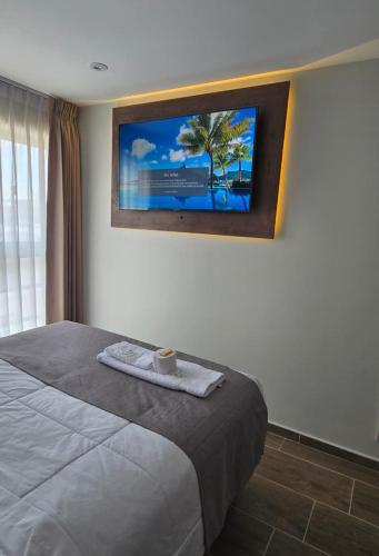 a bedroom with a bed with a tv on the wall at HB Selection Hotel in Miraflores