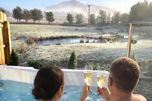 a man and woman holding glasses of wine in a hot tub at Mingarry Park in Acharacle