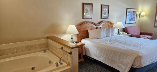 a hotel room with a bed and a bath tub at Homestead Suites - Fish Creek in Fish Creek