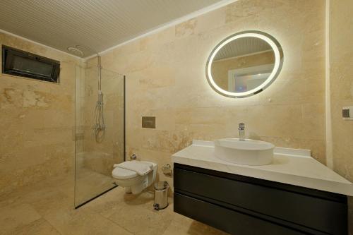 a bathroom with a sink and a toilet and a mirror at Villa Sheyma in Kalkan