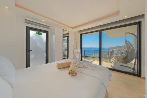 a bedroom with a white bed with a view of the ocean at Villa Sheyma in Kalkan