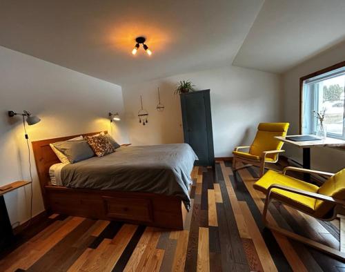 ein Schlafzimmer mit Bett, Schreibtisch und Stühlen in der Unterkunft Le Perchoir in Saint-Félix-d'Otis