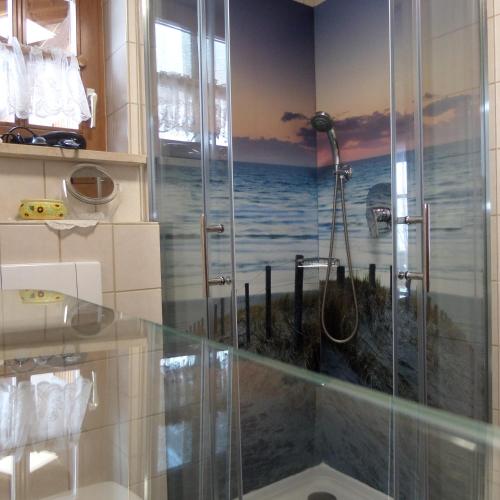 a bathroom with a shower with a painting of the ocean at Lehnhäusl Aschauer in Berchtesgaden