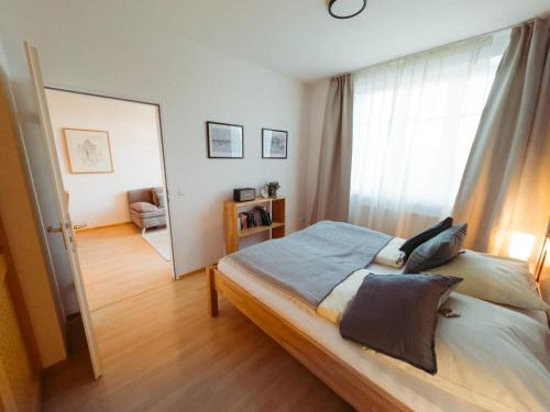 a bedroom with a bed and a large window at Ferienwohnung Ammersee in Andechs