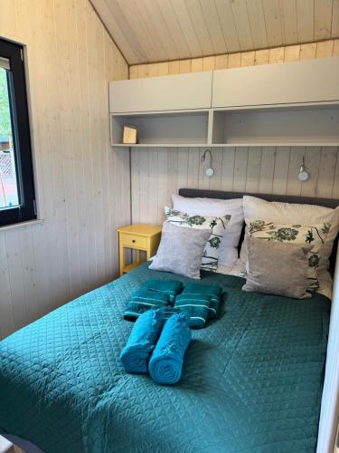 a bed in a small room with blue pillows on it at Sosnowe Zacisze in Dębki