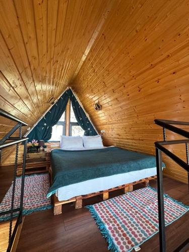 a bed in a room with a wooden ceiling at Silent Hill მშვიდი გორა in Batumi