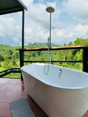 a bath tub on a deck with a view at เขากิวเทอเรส @สิชล in Sichon