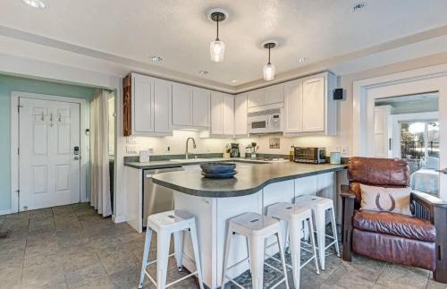 a kitchen with a large island with bar stools at Riverfront Cottage - Steam Room & Pet Friendly in Bend