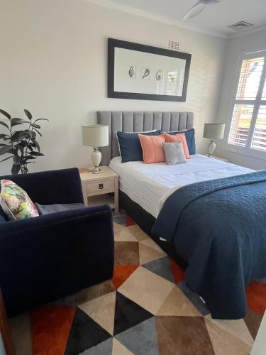 a bedroom with a bed and a couch and a chair at Campbell comfort and convenience in Campbell