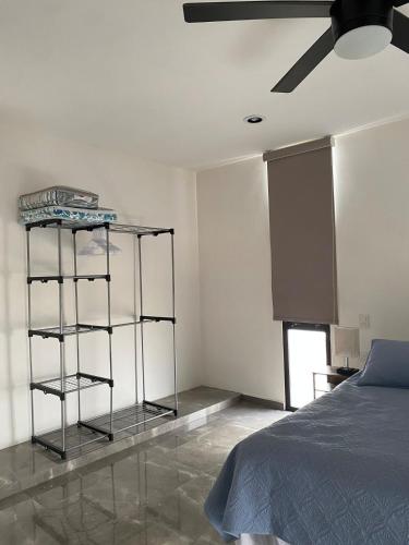 a bedroom with a bed and a ceiling fan at Otoch de Paz in Cholul