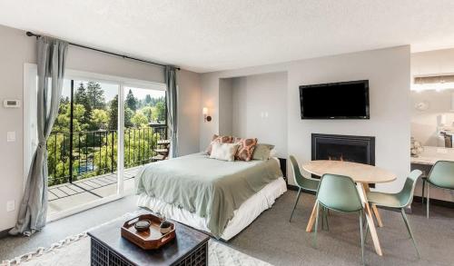 a bedroom with a bed and a table and a fireplace at Riverview Pet Friendly Condo in Downtown Bend in Bend