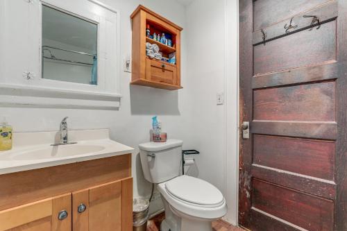 a bathroom with a toilet and a sink and a door at 8 Mi to Micron Technology! Walkable Phoenix Gem in Phoenix