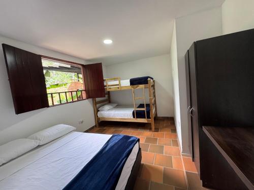 a small bedroom with a bed and a window at Finca Sol y Luna in San Gil