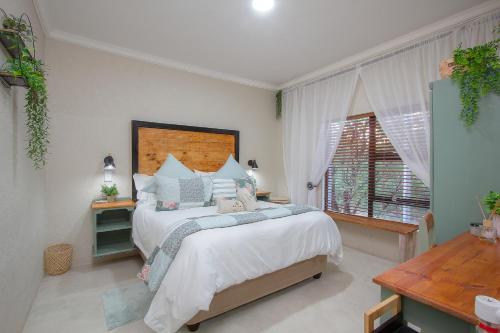 a bedroom with a large bed and a window at Edjami River View in Marloth Park