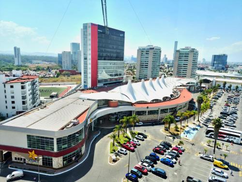 a large building with a parking lot in a city at Wyndham Puebla Angelopolis in Puebla