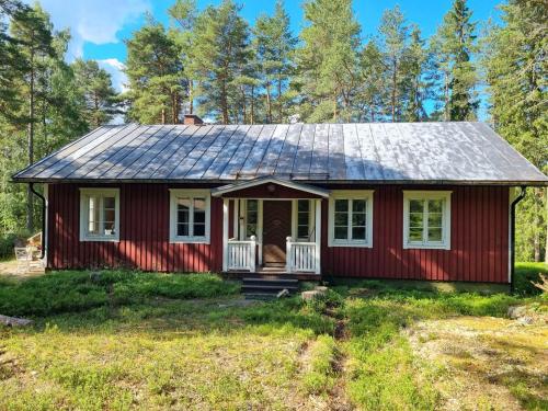 a red house with a solar roof on a yard at The River House & Riverside Sauna in Kokkola