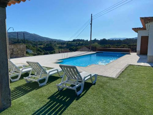 two chairs and a swimming pool in a yard at Casa das Portelas in Ponte de Lima