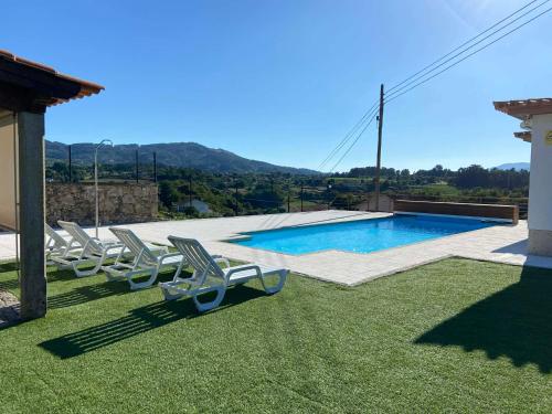 a group of chairs sitting next to a swimming pool at Casa das Portelas in Ponte de Lima
