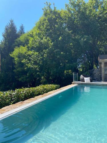 a swimming pool in a yard with trees at Casa do Cebro Casa con piscina y jacuzzi privados in Santiago de Compostela