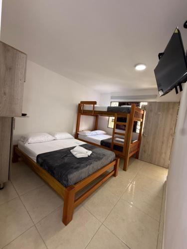 a bedroom with two bunk beds and a tv at Apartaestudio grupal privado dentro de hotel in Medellín