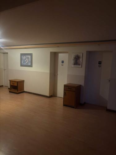 an empty room with two tables and paintings on the wall at Rama Vona UG in Wülknitz