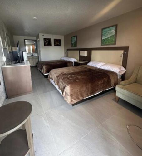 a hotel room with two beds and a couch at Gardenview Motel in Tampa