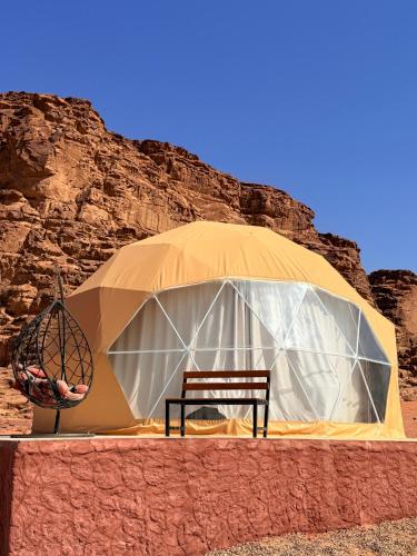 a tent with a chair in front of it at Mangle luxury rum camp in Disah
