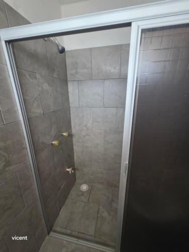 a shower with a glass door next to a shower at Nómadas in San Luis