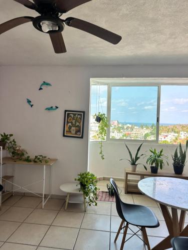 a living room with a ceiling fan and a table at Departamento en Acapulco Caleta in Acapulco
