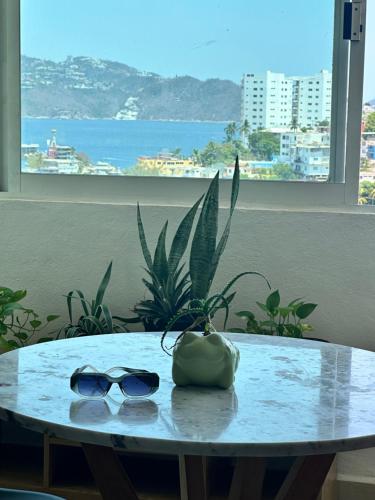 a table with a pair of sunglasses on it at Departamento en Acapulco Caleta in Acapulco