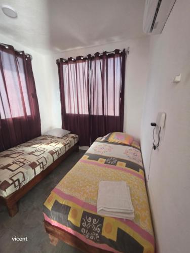 two beds sitting in a room with windows at Nómadas in San Luis
