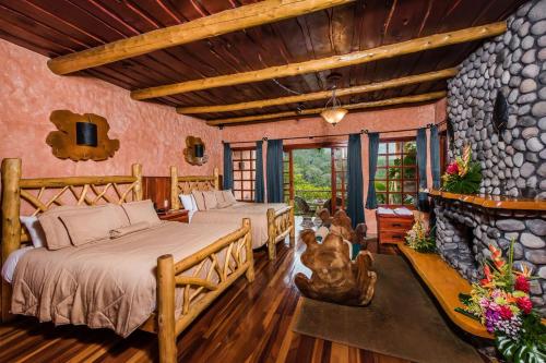 a bedroom with two beds and a stone wall at Peace Lodge in Vara Blanca