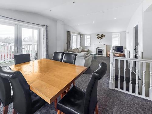 a dining room with a wooden table and black chairs at Royal Retreat in Wisbech